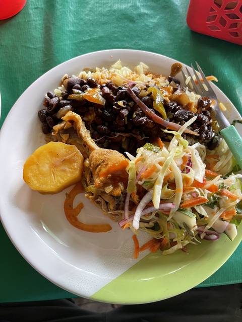 Plate with various foods, including beans and salad.