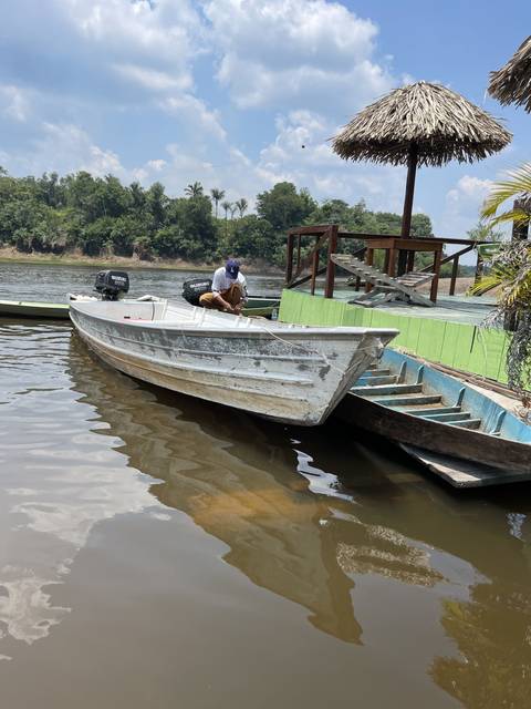 Person working on a docked boat with a river view.