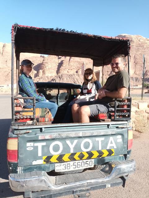 Group of people in a jeep in a desert area.