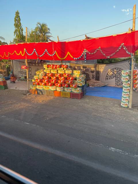 Outdoor shop with piles of goods, possibly food or products, displayed.