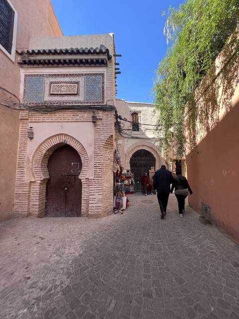 A street view with a couple walking past arches and designs.