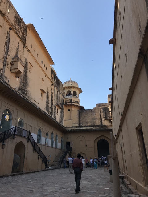 View of a historic building courtyard with a tower in the background.