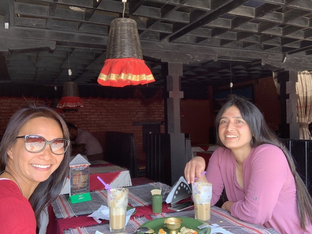 Two women sitting inside a restaurant with drinks.