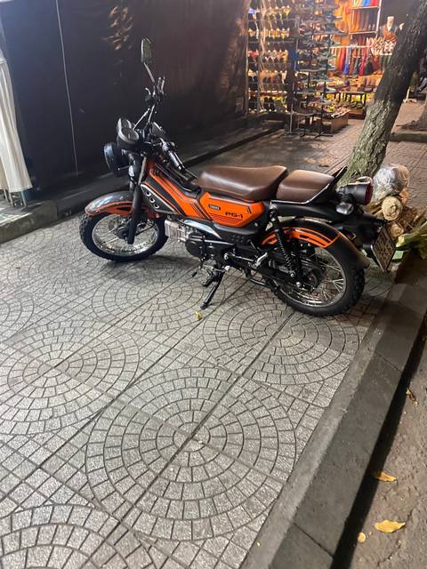 A parked motorcycle on a tiled sidewalk.