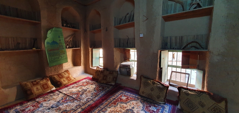 Traditional room interior with rugs and cushions on the floor.