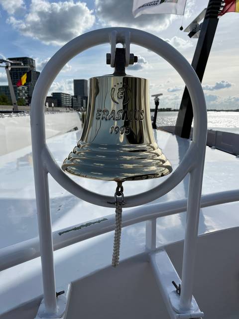 A shiny ship's bell with the name 'ERASMUS 1995'.