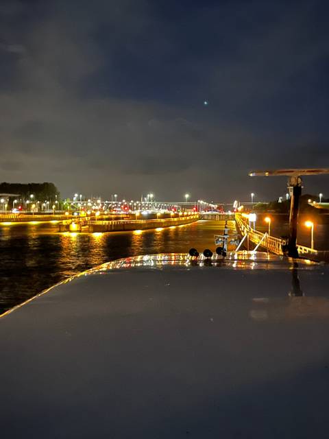 Night view of a river with lights reflecting on the water.