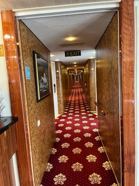 Interior corridor of a ship with a red carpet.