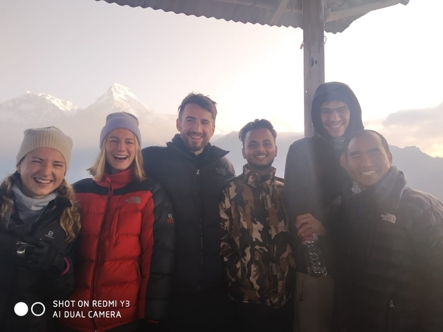 Group of people smiling with snowy mountains in the background