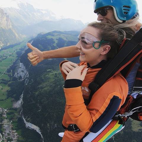 Person skydiving over a scenic landscape.