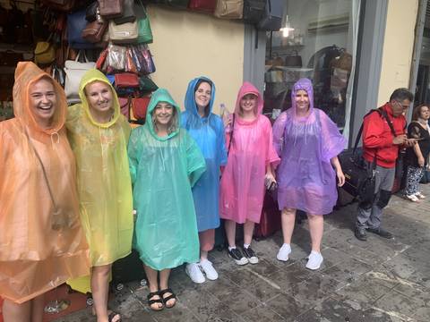 Group of friends wearing colorful rain ponchos.