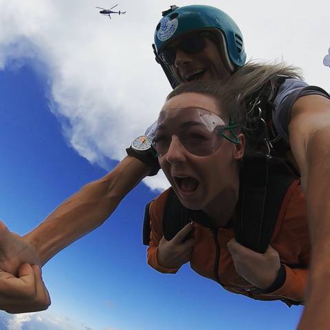 Person screaming while skydiving wearing goggles.