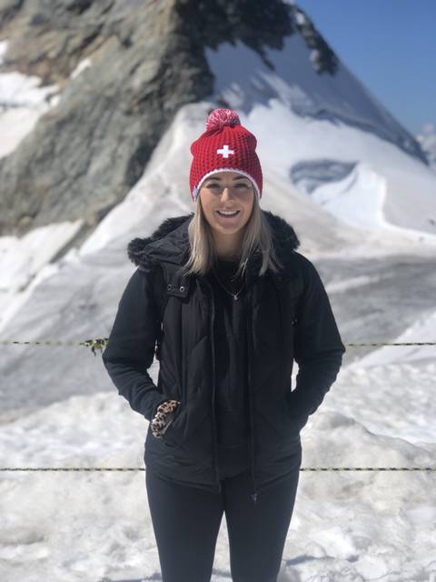 Woman posing in front of a snowy mountain landscape.