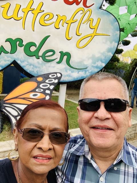 Close-up of a couple with a butterfly sign in the background.