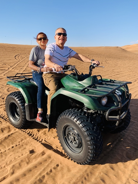 Two people riding an ATV in the desert.