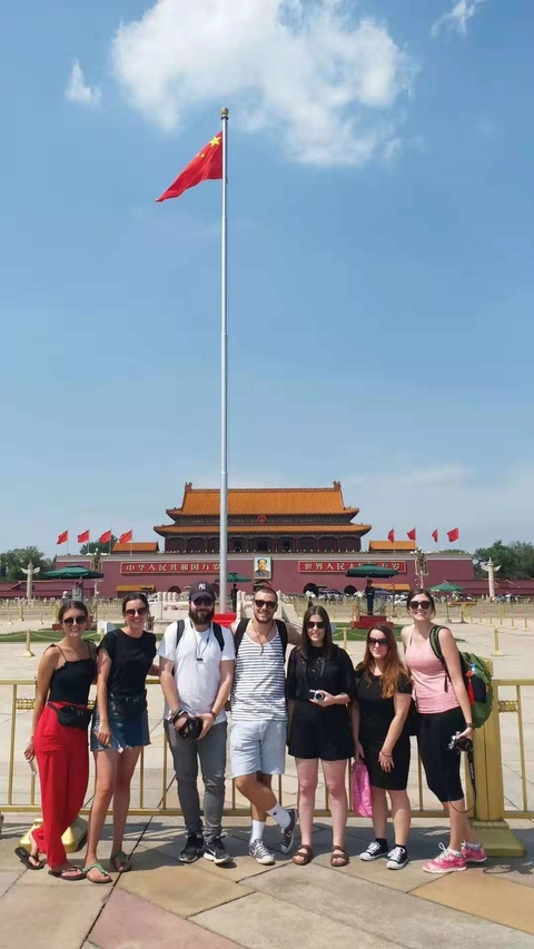 Group posing with the Forbidden City's entrance in the background.