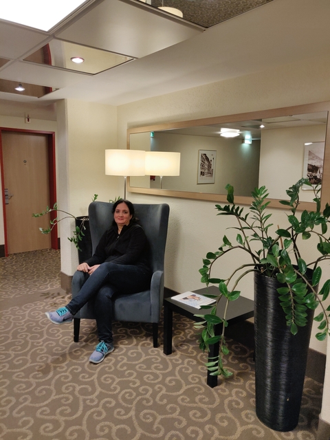 Woman sitting in a hotel lounge with chic decor.