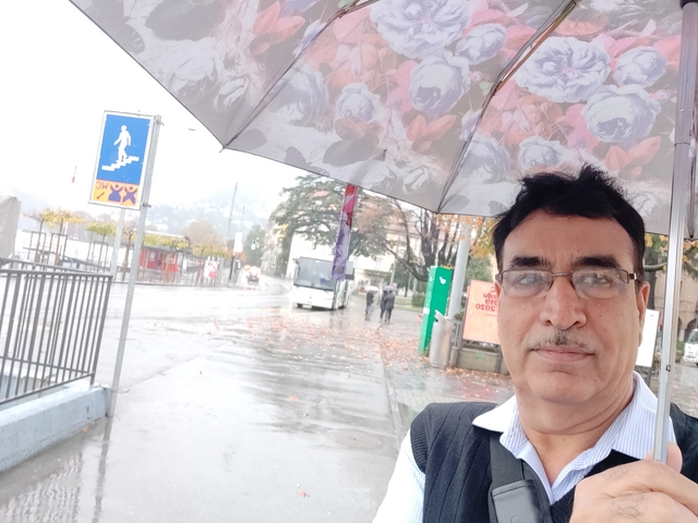 Man with umbrella on a rainy day in a city environment.