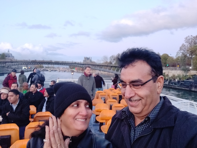Couple on a boat ride with city bridges in the background.