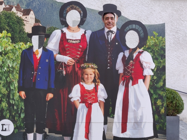Cutout board with traditional costumes, missing faces.