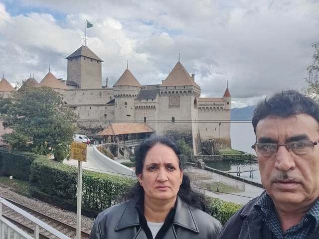 Couple posing in front of a large historic building.