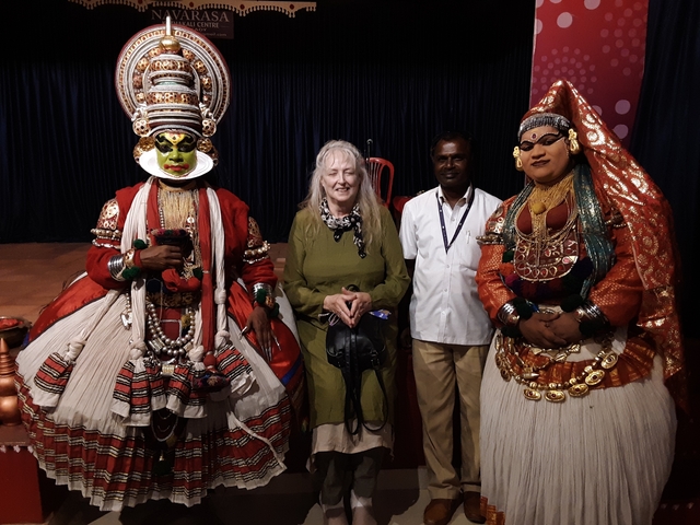 Three people including cultural performers in costume.