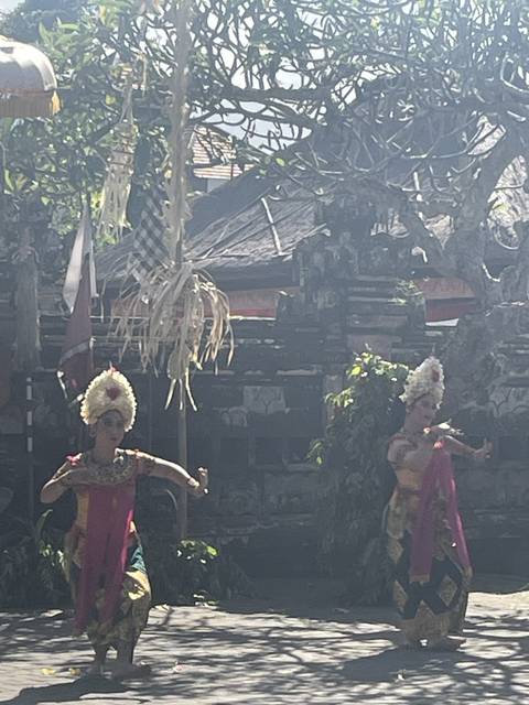 Traditional Balinese dancers in an outdoor setting.
