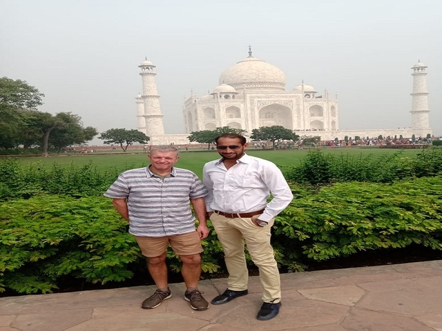 Two men posing in front of the Taj Mahal.