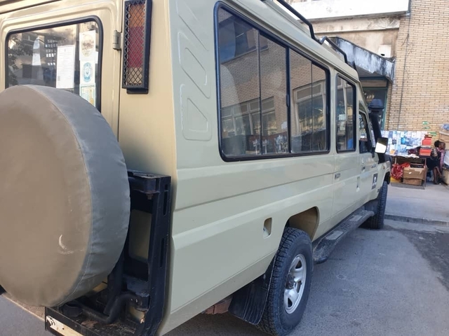 Side view of a safari vehicle parked in a street.