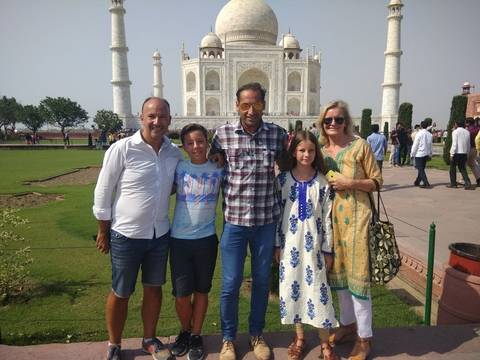 Family posing in front of the Taj Mahal.