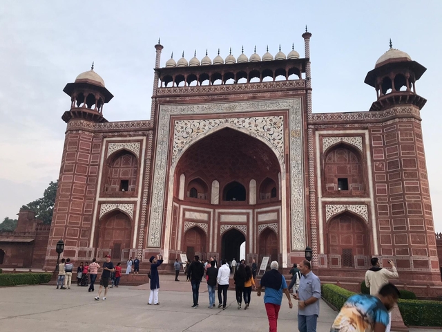 Large crowd near a historical gate at sunset.