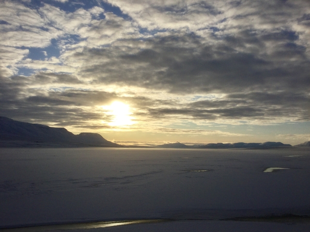 Sunset landscape with snowy mountains and dramatic clouds.