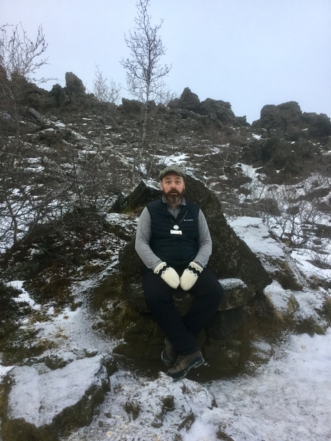 A person with snow and rocks as a backdrop looking surprised.