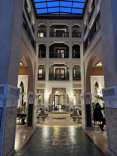 A hotel interior with arched architecture and people dining.