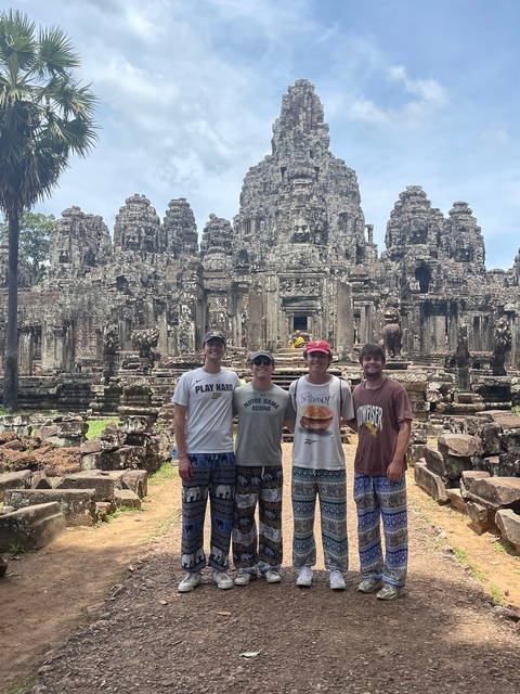 Group of four people in front of an ancient temple.