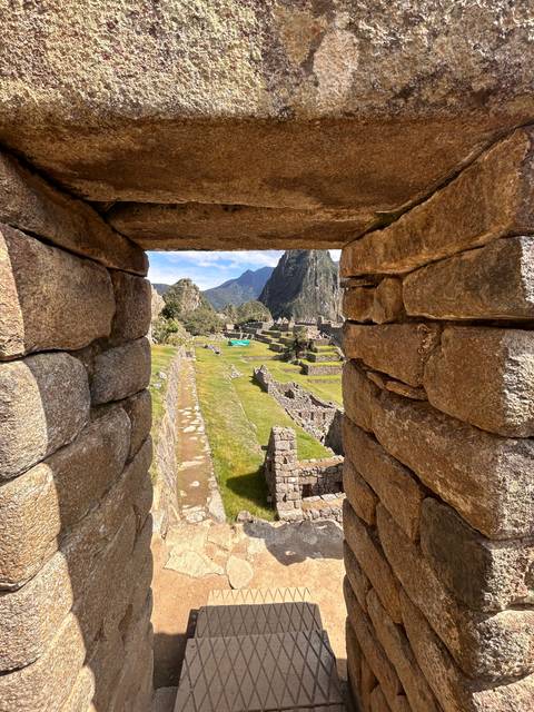 Stone doorway with view of ancient ruins and mountains.