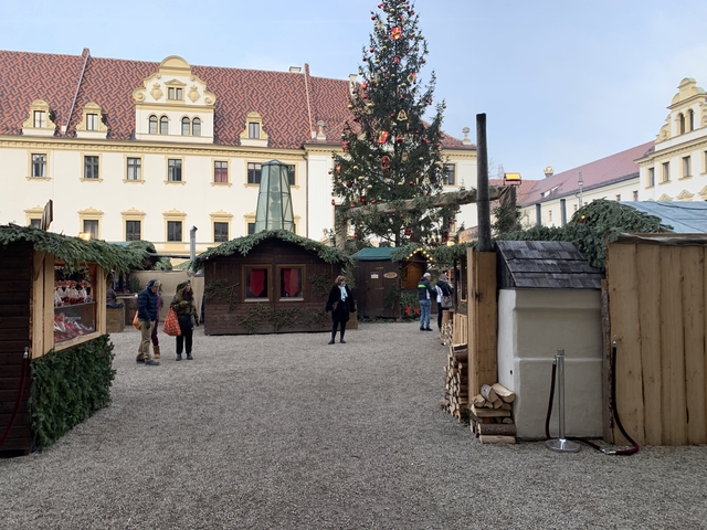Christmas market with wooden stalls and a decorated tree.