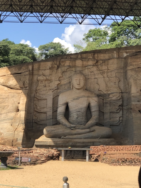 Carved stone Buddha statue in a serene setting.