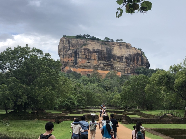 Majestic rock fortress surrounded by lush greenery.