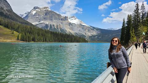 Mountain lake with people and forested shore.