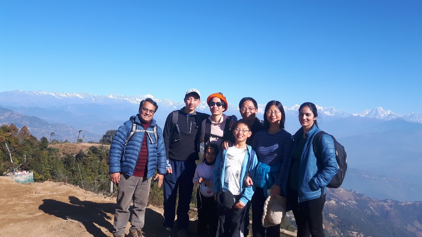 Family group posing with mountain view.