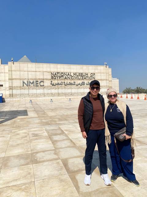 Two tourists standing near the entrance of a museum.