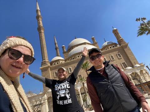 Three people posing with a historical building.