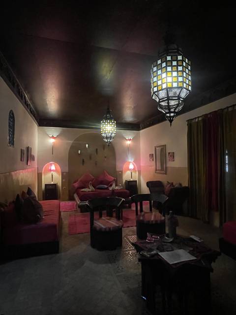 Interior of a Moroccan style room with colorful cushions and lamps.