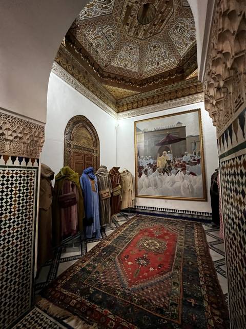 Antique-looking clothing on display in an ornate setting.