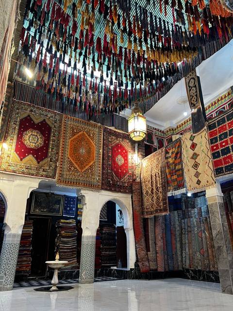 An indoor market with vibrant textiles and rugs.