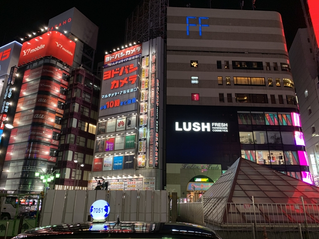 Brightly lit buildings at night in a city.
