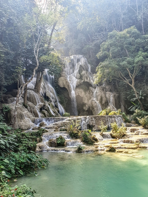 Large cascading waterfall in a lush forest.