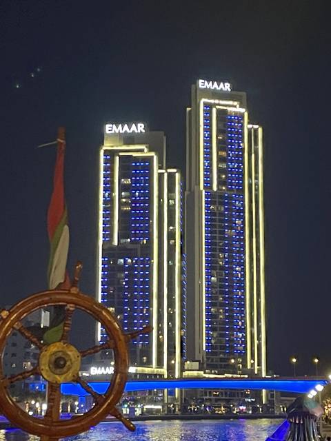 Tall illuminated buildings with the word 'Emaar' on them at night.