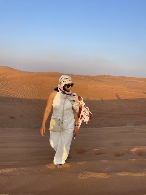 Person in traditional clothing in a desert setting.